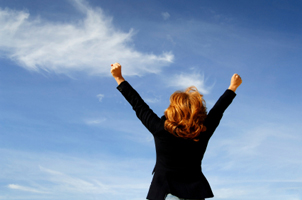 woman raising arms to the sky in triumph